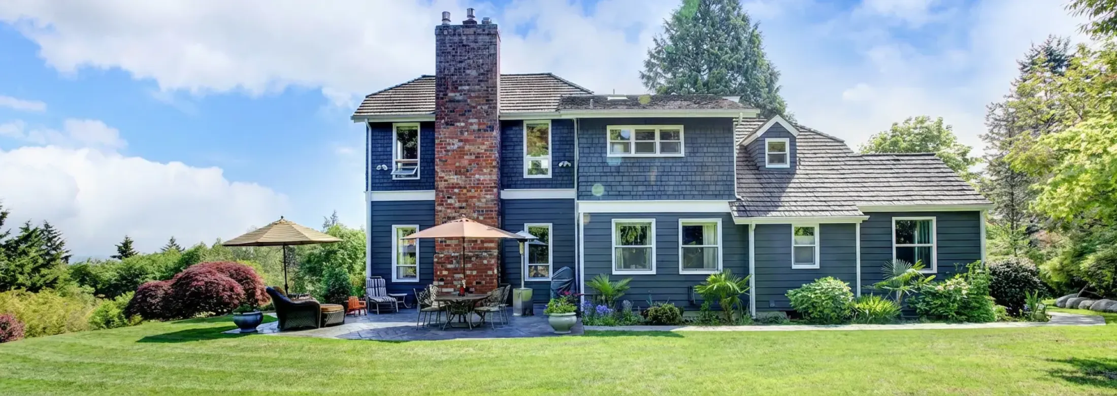 big blue house with beautiful healthy green lawn